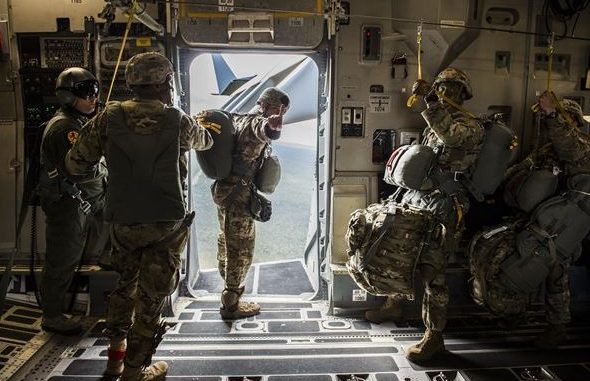 A Jumpmaster signals "1 minute" warning during a paratroop drop over Australia during Exercise Talisman Saber 2017. (Photo by Tech Sgt Gregory Brook, USAF, July 12, 2017)