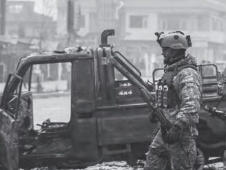 Afghan security force members walk past a bombed truck in Kabul (AFP photo by Zakeria Hashimi)
